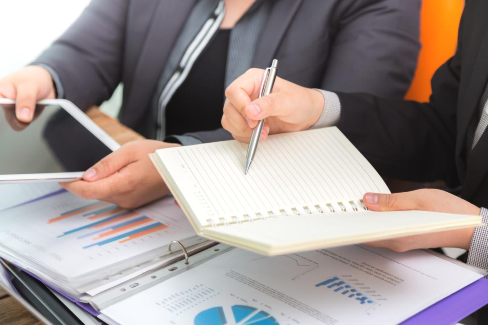 Mesa de trabajo con documentos financieros, calculadora y gráficos de planificación